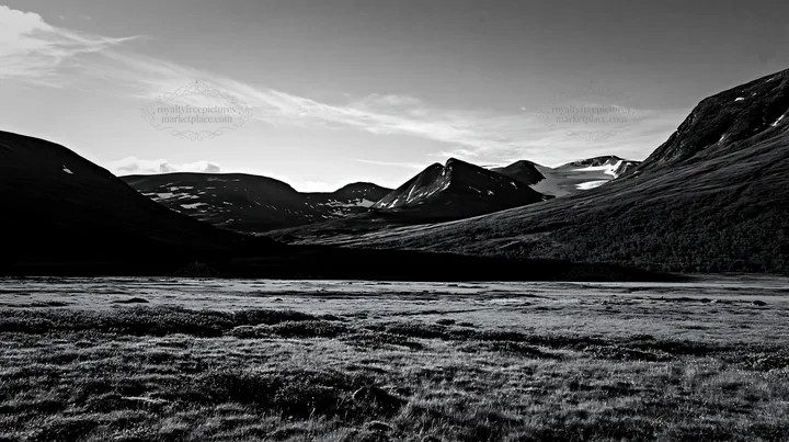 Sunbeams over Jotunheimen valley meadow in black and white - AI-generated stock image